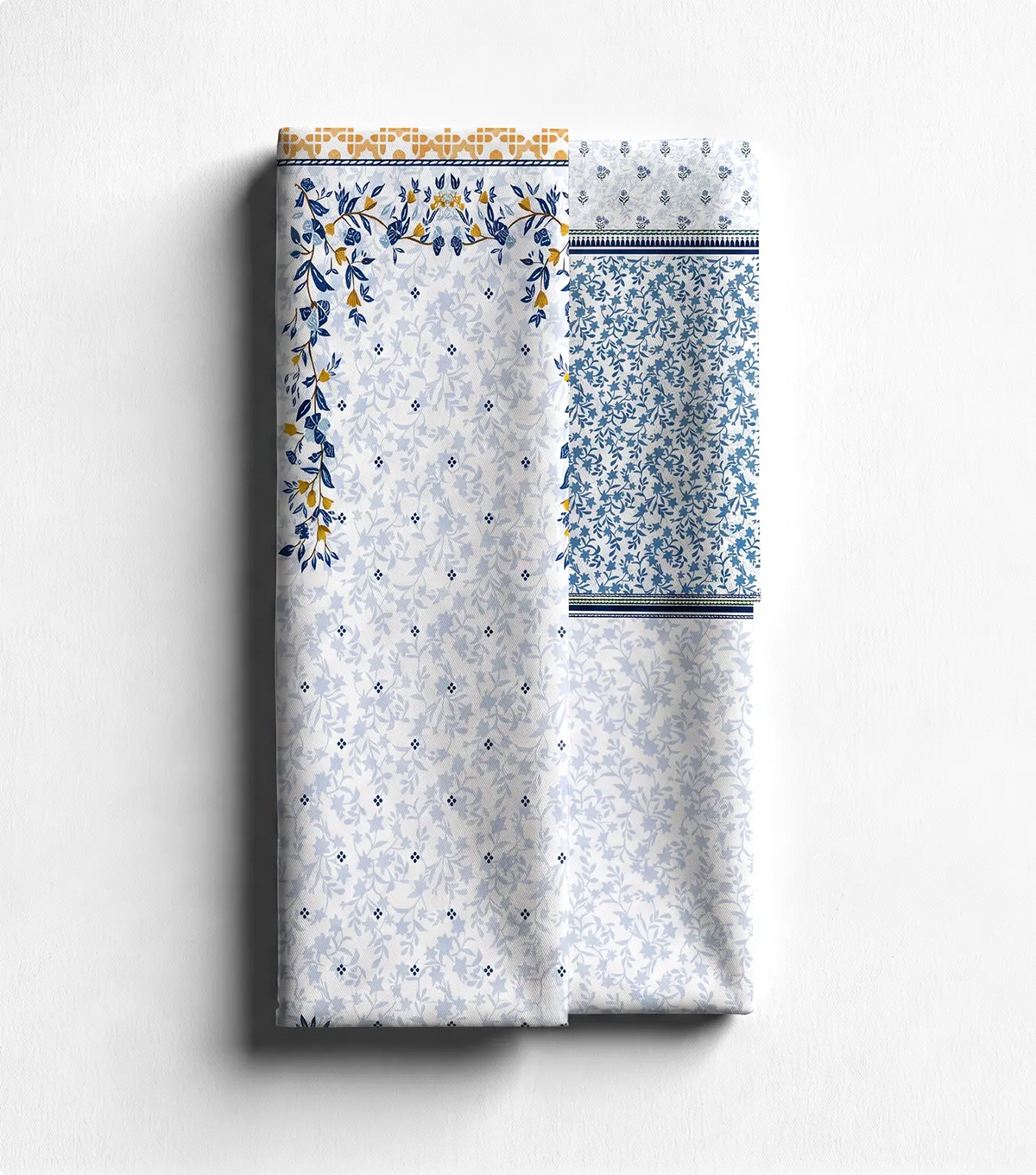 Unstitched ivory lawn shirt panel with blue floral border beside matching trouser fabric