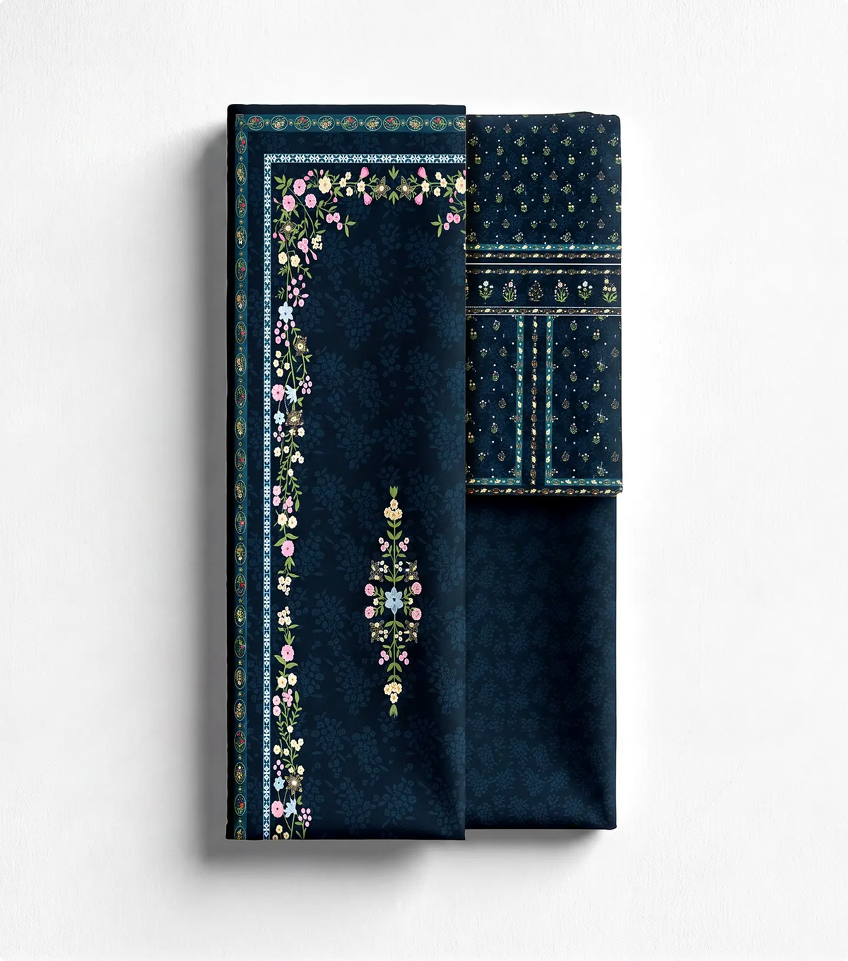 Unstitched navy blue lawn shirt panel with floral border print beside matching trouser fabric