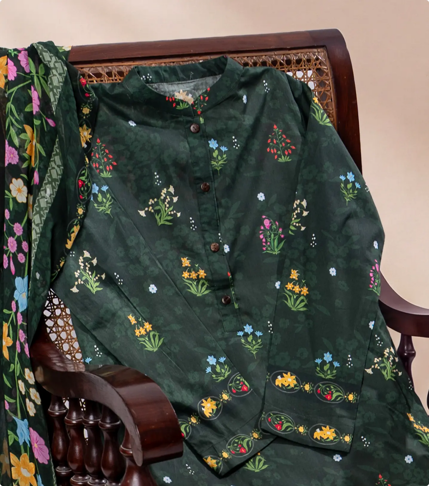 Forest green wildflower print lawn kurta draped over a dark wooden cane chair
